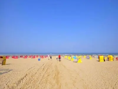 a group of people walking on the beach at Holiday Home in Bergen near North Sea Beach in Bergen aan Zee