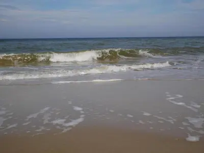 a sandy beach with waves in the ocean at Holiday Home in Bergen near North Sea Beach in Bergen aan Zee