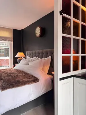 a bedroom with a bed and a clock on the wall at The Lastage Inn - Bed & Breakfast in Amsterdam