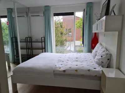 a bedroom with a bed and a large window at Johan's B&B - Since 2014 roofterrace and cheap parking in Amsterdam