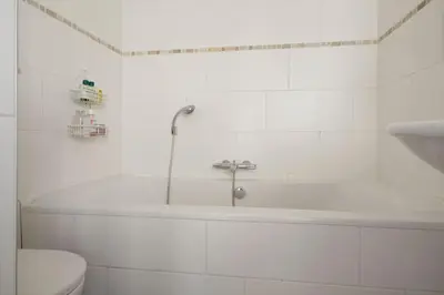 a white bathroom with a tub and a toilet at Johan's B&B - Since 2014 roofterrace and cheap parking in Amsterdam