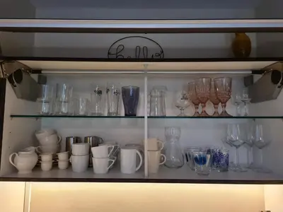 a shelf filled with glass vases and other glass items at GREAT CANAL STUDIO - AC, Water view & Free parking in Amsterdam