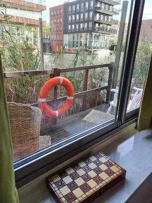 a window with a life preserver on a balcony at GREAT CANAL STUDIO - AC, Water view & Free parking in Amsterdam