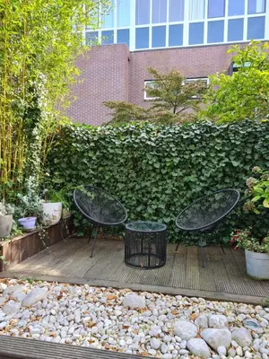 two chairs and a trash can sitting on a patio at GREAT CANAL STUDIO - AC, Water view & Free parking in Amsterdam
