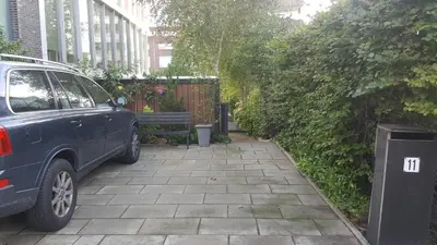 a blue car parked on a sidewalk next to a bench at GREAT CANAL STUDIO - AC, Water view & Free parking in Amsterdam