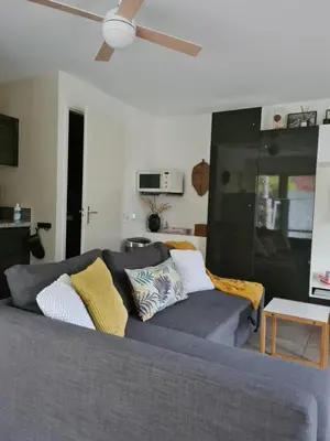 a living room with a couch and a ceiling fan at GREAT CANAL STUDIO - AC, Water view & Free parking in Amsterdam