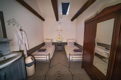 a bathroom with two beds and a sink and a mirror at Veldzicht in Winkel