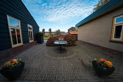 a patio with a table and some pumpkins on it at Veldzicht in Winkel