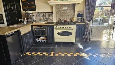 a kitchen with a stove and a sink in it at Veldzicht in Winkel