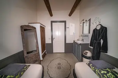 a bathroom with two beds and a sink and a mirror at Veldzicht in Winkel