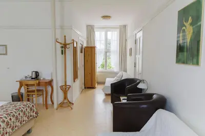 a living room with a couch and chairs and a table at Landgoed Huize Glory in Bergen aan Zee