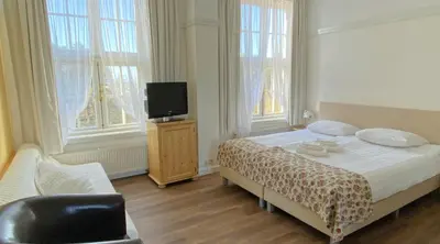 a bedroom with a bed and a tv in it at Landgoed Huize Glory in Bergen aan Zee
