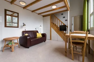 a living room with a couch and a table at Landgoed Huize Glory in Bergen aan Zee