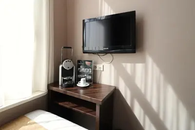 a room with a tv on a wall with a table at Hotel Van Gogh in Amsterdam