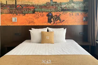 a bedroom with a bed with a painting on the wall at Hotel Van Gogh in Amsterdam