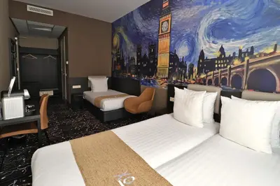 a hotel room with two beds and a painting on the wall at Hotel Van Gogh in Amsterdam