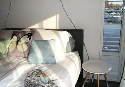 a bed with butterfly pillows on it with a table at watervilla-albertje in Amsterdam