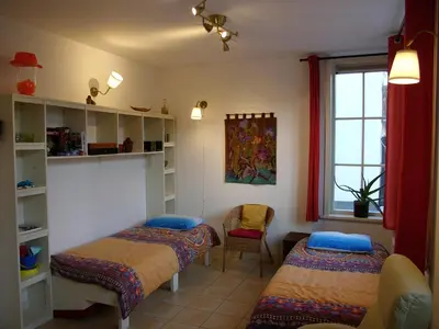 a room with two beds and a window at Dar Cho Apartment in Zandvoort