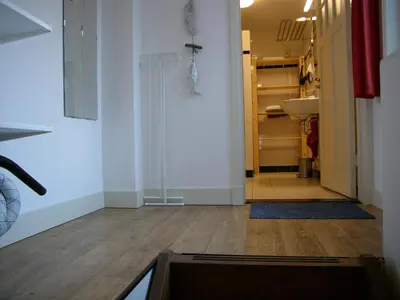 a hallway with a room with a closet and a sink at Dar Cho Apartment in Zandvoort