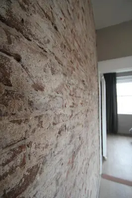 a brick wall in a room with a window at Het Spoorhuis Uithoorn in Uithoorn