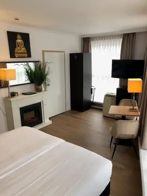 a hotel room with a bed and a fireplace at Hotel de Keizerskroon Hoorn in Hoorn