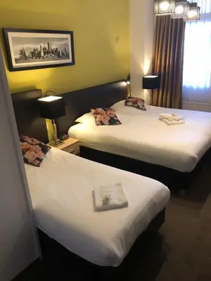 a hotel room with two beds with a book on them at Hotel de Keizerskroon Hoorn in Hoorn