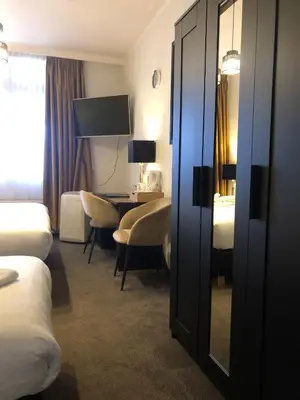 a hotel room with a bedroom with a desk and a bed at Hotel de Keizerskroon Hoorn in Hoorn