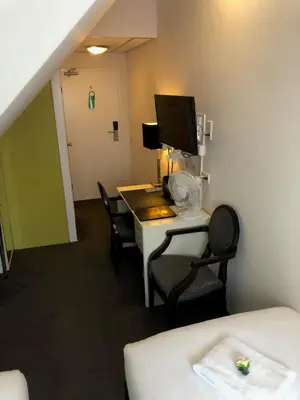 a room with a desk with a computer and chairs at Hotel de Keizerskroon Hoorn in Hoorn