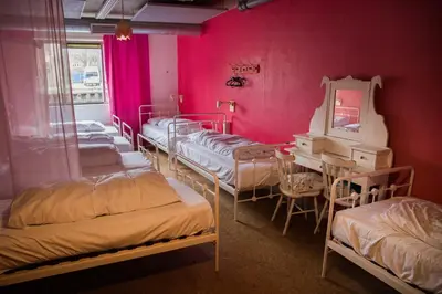 a room with four beds and a mirror and a table at ClinkMama in Amsterdam