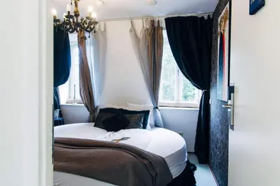 a bedroom with a bed with a black cat sitting on it at ClinkCoco in Amsterdam