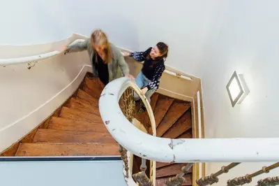 two women are walking down a spiral staircase at ClinkCoco in Amsterdam