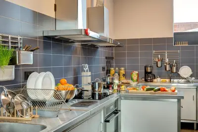 a kitchen with blue tiled walls and a counter top at MEININGER Hotel Amsterdam Amstel in Amsterdam