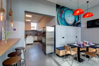 a kitchen and dining room with a table and chairs at MEININGER Hotel Amsterdam Amstel in Amsterdam