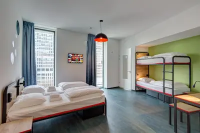 a bedroom with three bunk beds and a table at MEININGER Hotel Amsterdam Amstel in Amsterdam