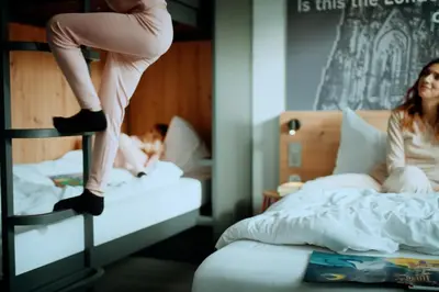 a woman is sitting on a bunk bed at MEININGER Hotel Amsterdam Amstel in Amsterdam