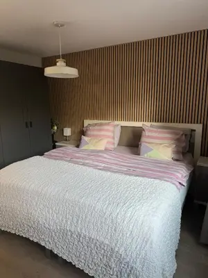 a bedroom with a large bed with white sheets and pillows at Chalet Parfait in Bergen