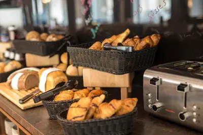 a bunch of baskets of bread on a counter at Holiday Inn - the niu, Dairy Haarlem in Haarlem