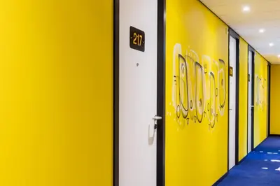 a hallway with yellow walls and a door with the number at Holiday Inn - the niu, Dairy Haarlem in Haarlem