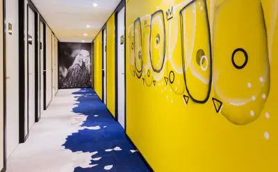 a hallway with yellow walls and a blue carpet at Holiday Inn - the niu, Dairy Haarlem in Haarlem