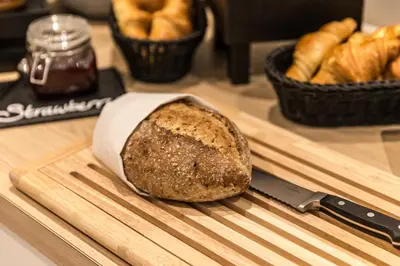 a loaf of bread on a cutting board with a knife at Holiday Inn - the niu, Dairy Haarlem in Haarlem