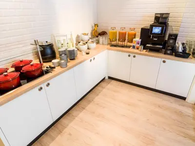 a kitchen with white cabinets and red pots and pans at Holiday Inn - the niu, Dairy Haarlem in Haarlem