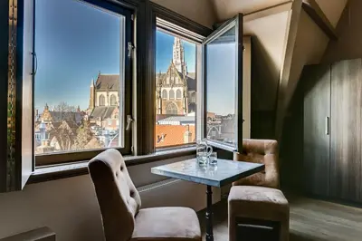 a room with a table and two chairs and a window at Brasss Hotel Suites in Haarlem