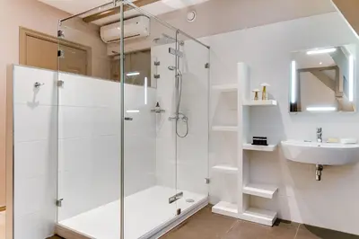 a bathroom with a shower and a sink at Brasss Hotel Suites in Haarlem