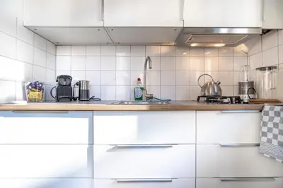 a kitchen with white cabinets and a counter top at Here's Lucy in Amsterdam