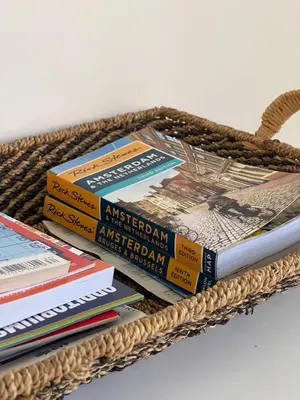a pile of books in a wicker basket at Here's Lucy in Amsterdam