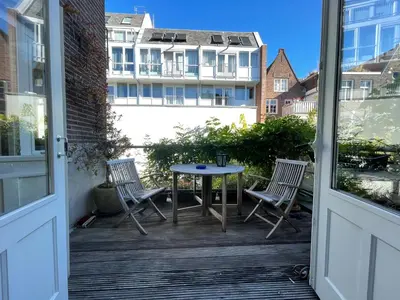 a patio with two chairs and a table on a balcony at Here's Lucy in Amsterdam
