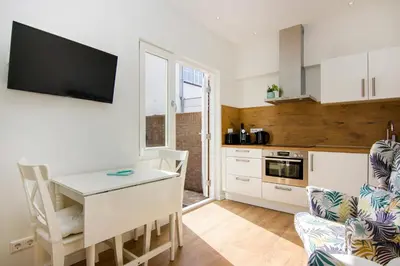 a living room with a table and a kitchen at Lou-Lou in Zandvoort