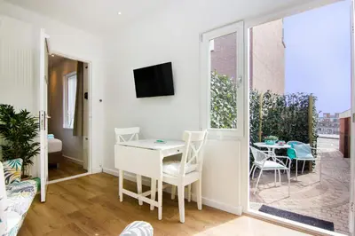 a small living room with a table and a balcony at Lou-Lou in Zandvoort