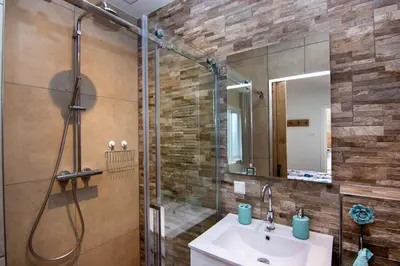 a bathroom with a shower and a sink and a mirror at Lou-Lou in Zandvoort