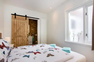 a bedroom with a bed and a window and a door at Lou-Lou in Zandvoort